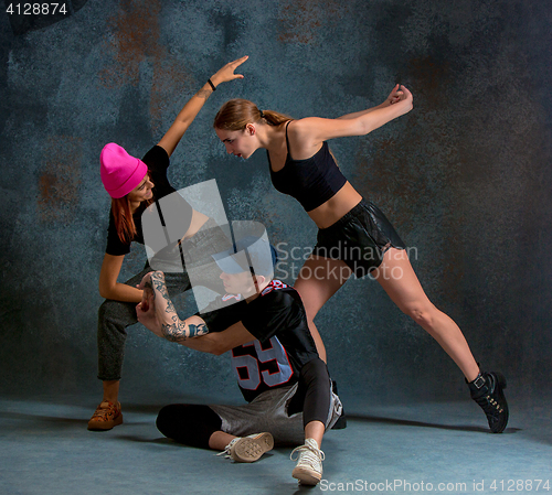 Image of The two young girsl and boy dancing hip hop in the studio
