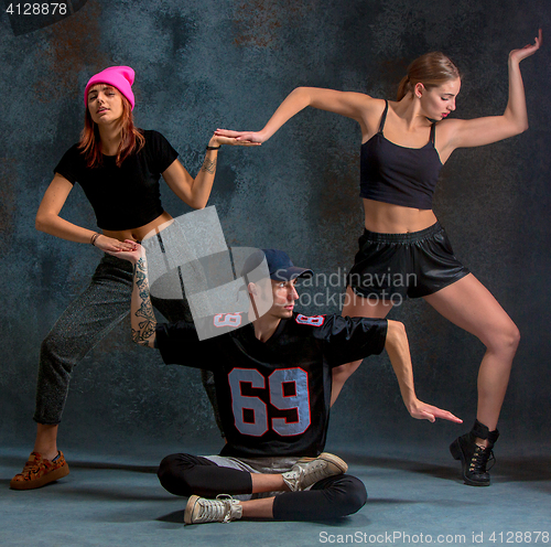 Image of The two young girsl and boy dancing hip hop in the studio