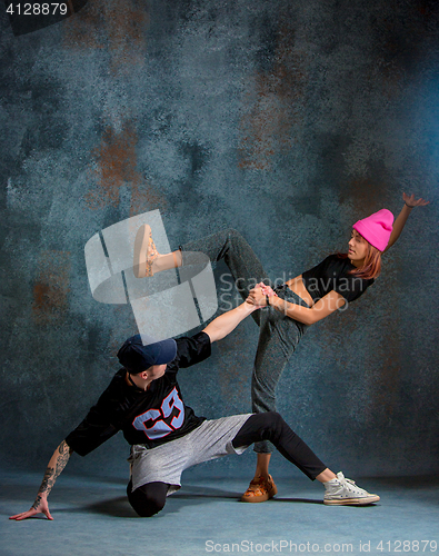 Image of The two young girl and boy dancing hip hop in the studio