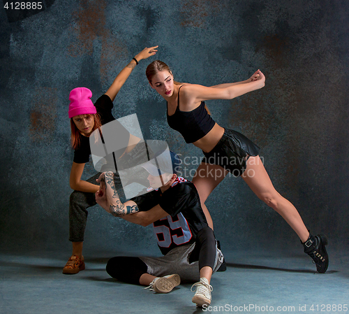 Image of The two young girsl and boy dancing hip hop in the studio