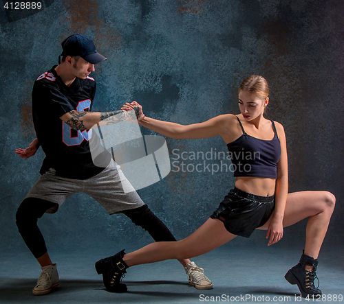 Image of The two young girl and boy dancing hip hop in the studio