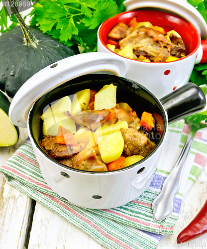 Image of Roast meat and vegetables in white pots on napkin