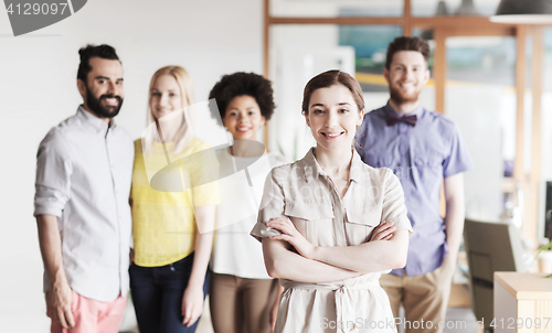 Image of happy young woman over creative team in office