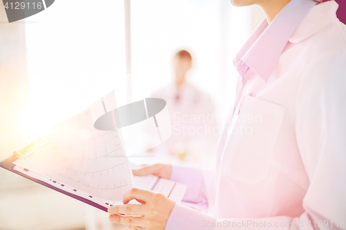 Image of female holding clipboard with cardiogram