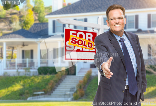 Image of Male Agent Reaching for Hand Shake in Front of House and Sold Re