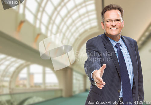 Image of Businessman Reaching for Hand Shake Inside Corporate Building