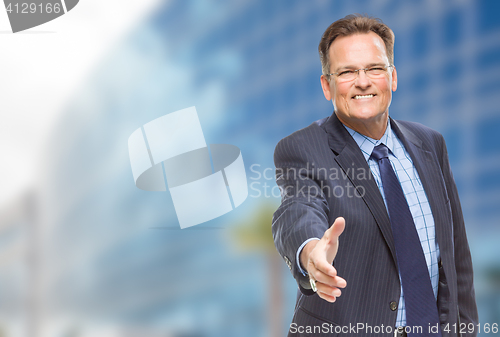 Image of Businessman Reaching for Hand Shake in Front of Building
