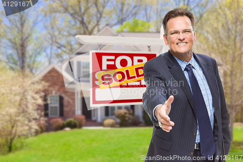 Image of Male Agent Reaching for Hand Shake in Front of House and Sold Re
