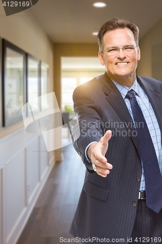 Image of Male Agent Reaching for Hand Shake in Hallway of House
