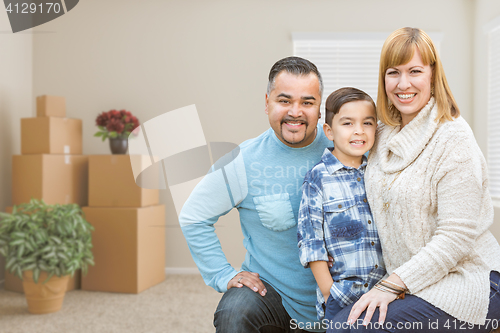 Image of Mixed Race Family with Son in Room with Packed Moving Boxes