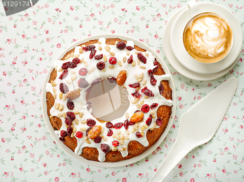 Image of freshly baked fruit cake and cup of cappuccino coffee