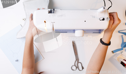Image of Girl with sewing-machine top view