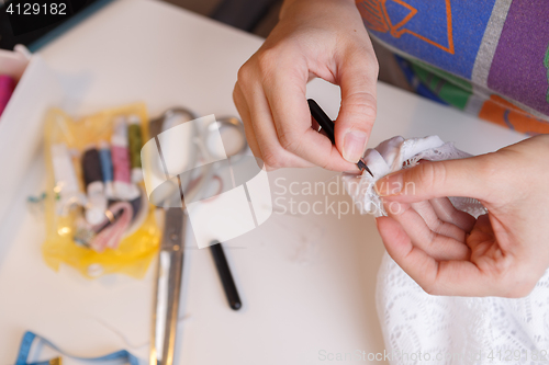 Image of Girl cuts thread in fabric