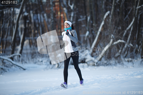 Image of Young brunette running among trees