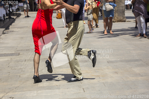 Image of Street dancers performing tango in the street among the people