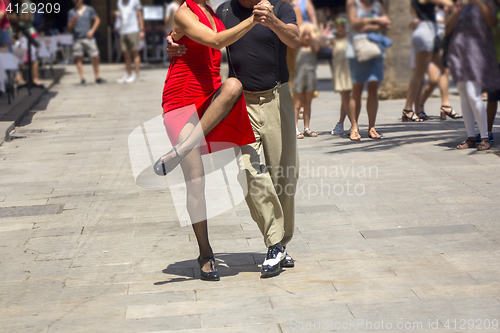 Image of Street dancers performing tango in the street among the people