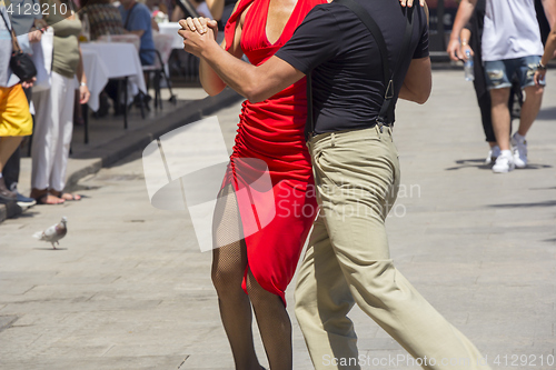 Image of Street dancers performing tango in the street among the people