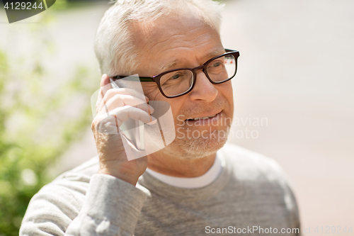 Image of happy senior man calling on smartphone in city