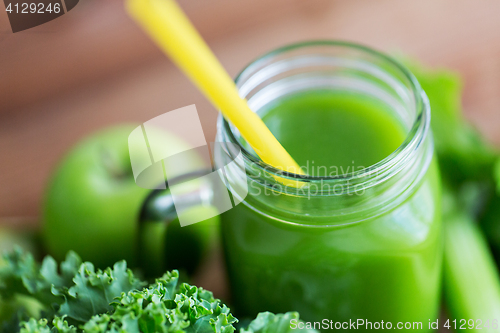 Image of close up of jug with green juice and vegetables