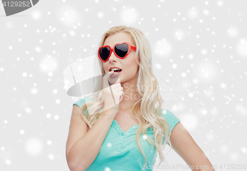 Image of happy woman or teenager in heart shaped sunglasses