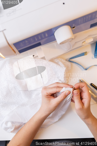 Image of Girl in atelier unrips fabric