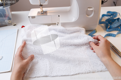 Image of Woman prepares fabric for sewing