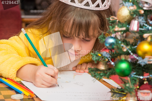 Image of The girl draws a picture in a letter to Santa Claus