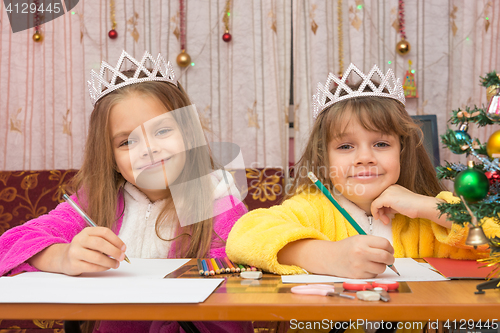 Image of Two girls write wishes for the new year