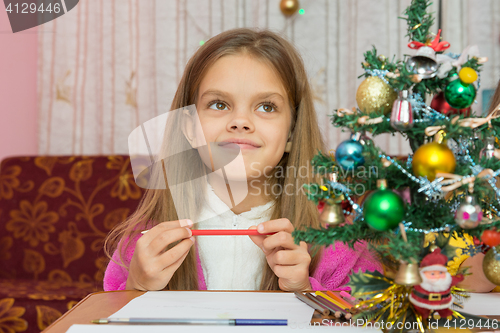 Image of Happy little girl thinking of a gift for the new year