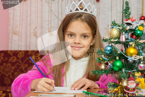 Image of A girl waiting for a new year, writes a letter to the desires and looked into the frame