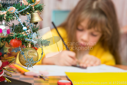 Image of Carried away by a girl making Christmas crafts, focusing on the fur-tree