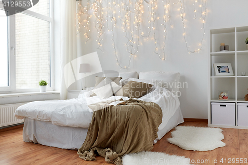 Image of bedroom with bed and christmas garland at home