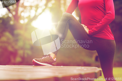 Image of close up of woman stretching leg outdoors