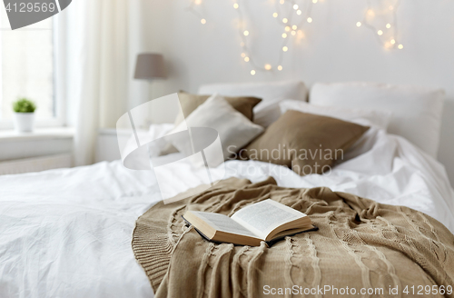 Image of bedroom with bed and christmas garland at home