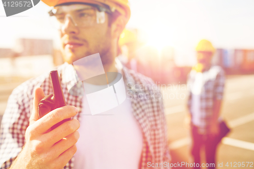 Image of close up of builder in hardhat with walkie talkie