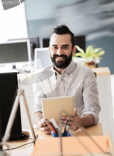 Image of happy creative male office worker with tablet pc
