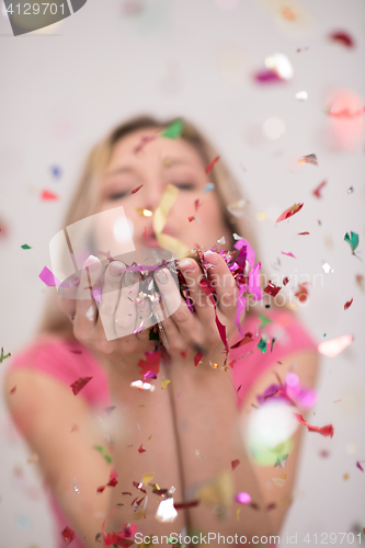 Image of woman blowing confetti in the air