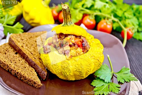 Image of Squash yellow stuffed with meat and vegetables on dark board