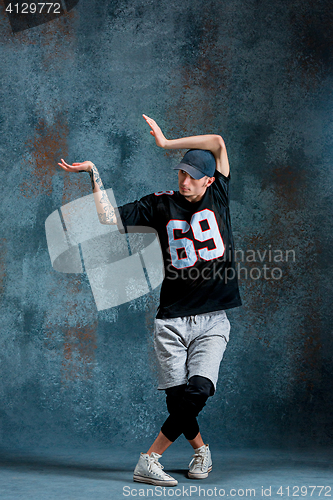 Image of Young man break dancing on wall background.