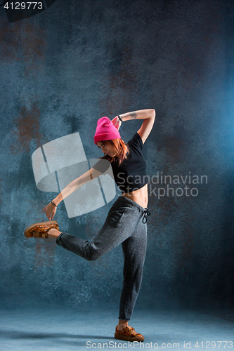 Image of Young girl break dancing on wall background.