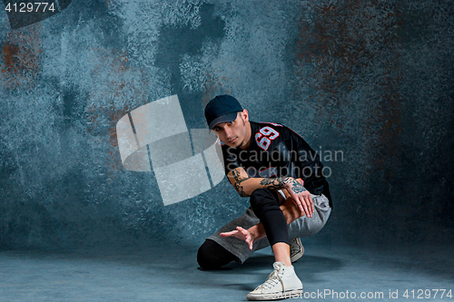 Image of Young man break dancing on wall background.