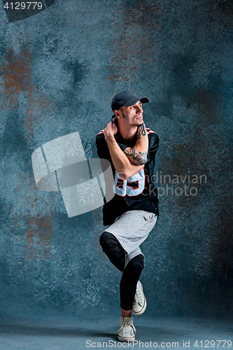 Image of Young man break dancing on wall background.