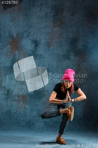 Image of Young girl break dancing on wall background.