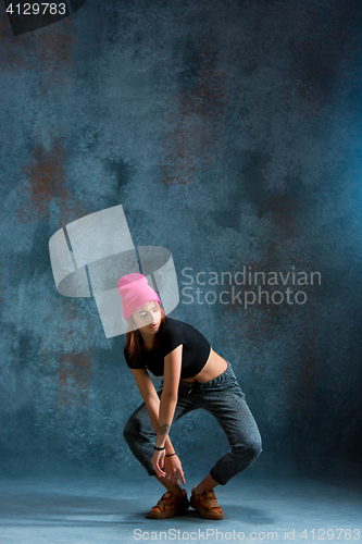 Image of Young girl break dancing on wall background.