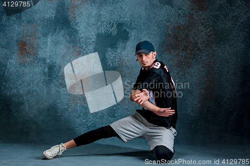 Image of Young man break dancing on wall background.