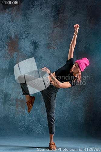 Image of Young girl break dancing on wall background.