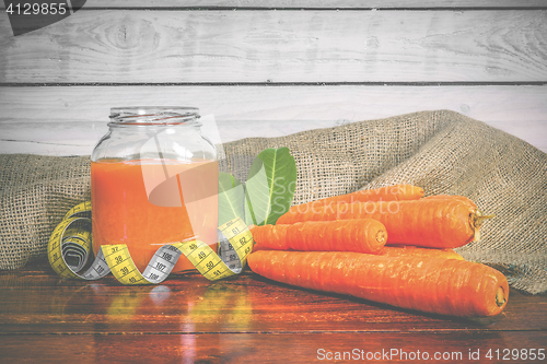 Image of Jar with carrot juice on a wooden table