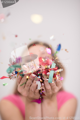 Image of woman blowing confetti in the air