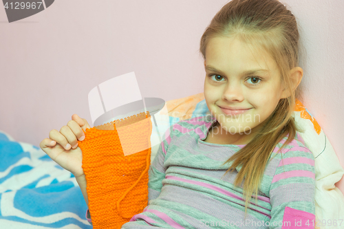 Image of Girl shows a scarf tied on needle