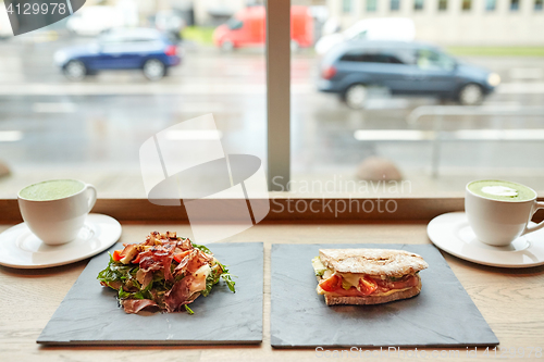 Image of salad, sandwich and matcha green tea at restaurant